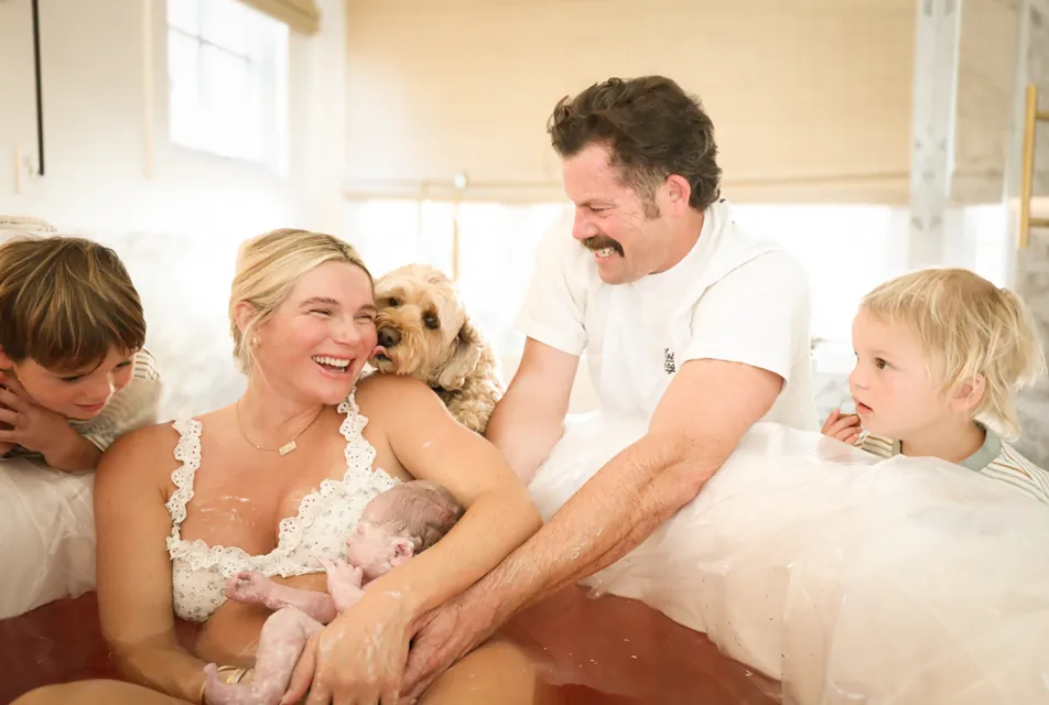 A family laughing together with their newborn moments after a home water birth