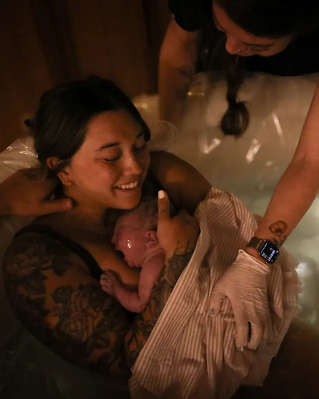 A newborn on mom's chest in the birth pool, Orange County birth photography by Jenn Miller