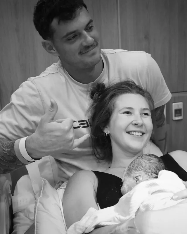 New parents smiling with their newborn, black and white birth photography by Jenn Miller, Orange County