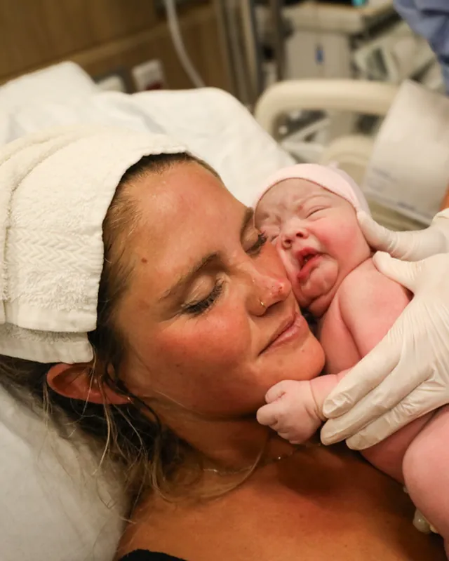 A mother holds her newborn cheek to cheek moments after birth, Orange County birth photography by Jenn Miller