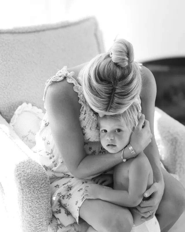 A mother holds her toddler close before the new baby arrives, black and white birth photography by Jenn Miller, Orange County