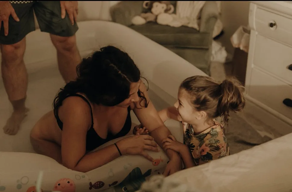 Jenn Miller in labor in the birth pool, face to face with one of her children