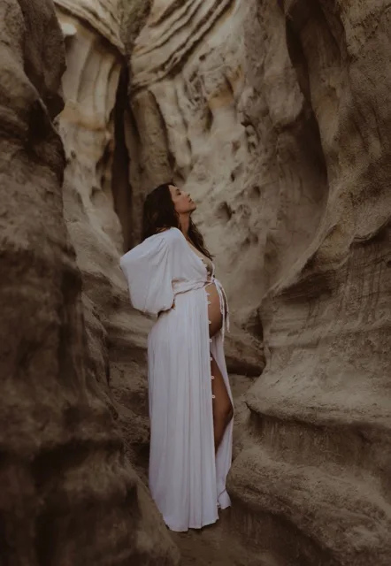 Jenn Miller, pregnant, standing among sandstone walls