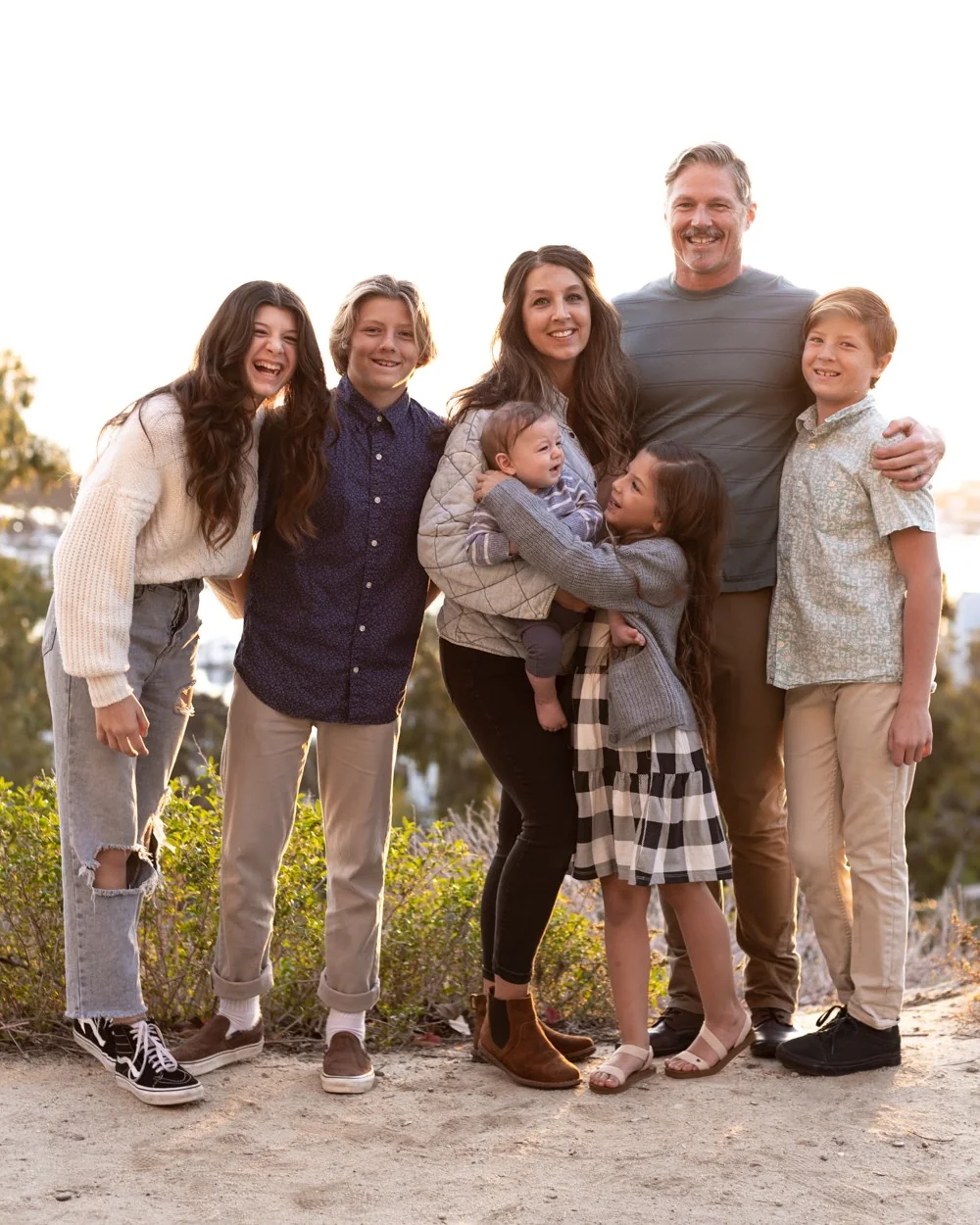 Jenn Miller with her husband and their five children, laughing together outdoors
